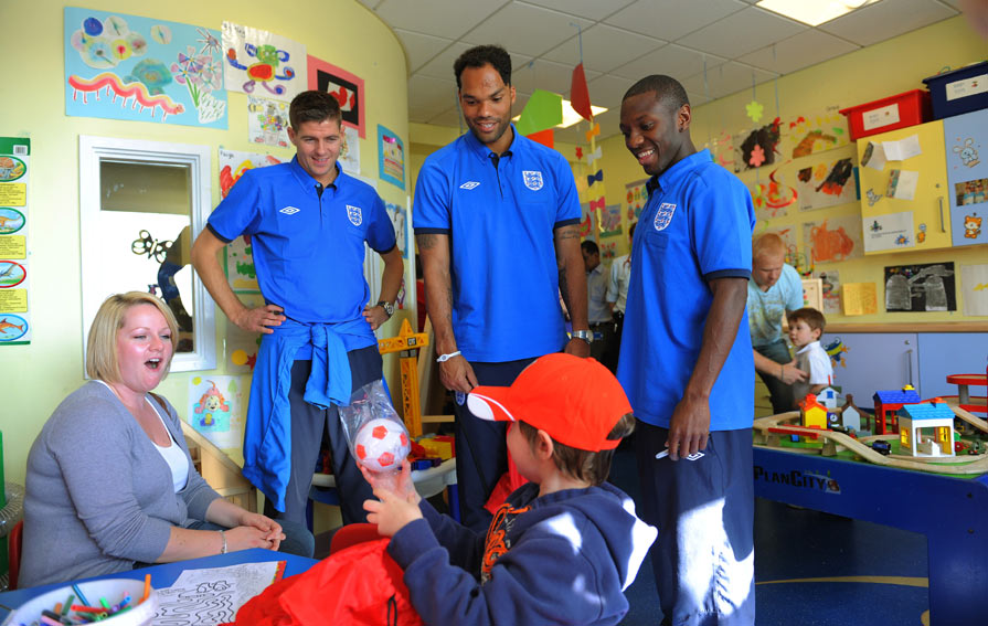 The England players look on as a young patient opens a gift.